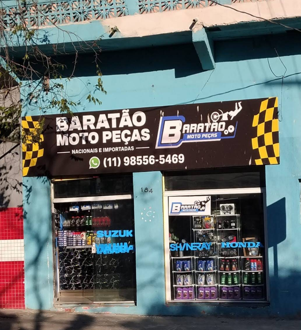 Fachada da loja Baratão Moto Peças na Rua Carijós, 184, com letreiro preto e vitrine de produtos